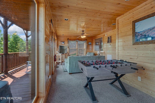 game room featuring wooden walls, vaulted ceiling, ceiling fan, light colored carpet, and wood ceiling