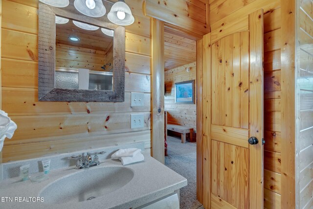 bathroom featuring wooden walls and vanity