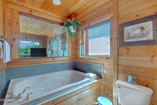 bathroom featuring a tub to relax in, wooden walls, wooden ceiling, and toilet