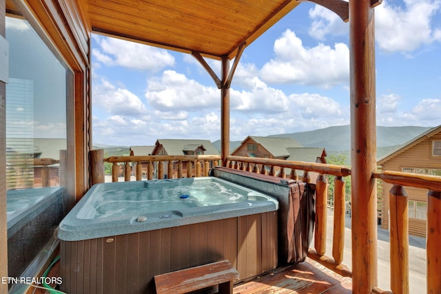 wooden terrace with a mountain view and a hot tub