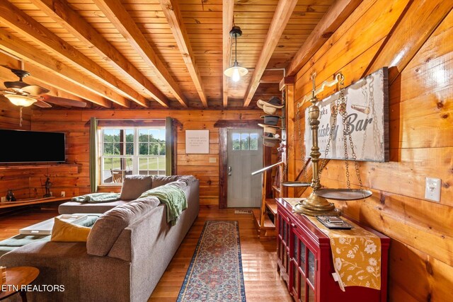 living room with wood ceiling, beamed ceiling, hardwood / wood-style floors, and ceiling fan