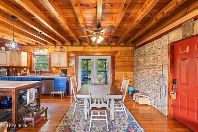 dining space with ceiling fan, sink, hardwood / wood-style floors, and beam ceiling