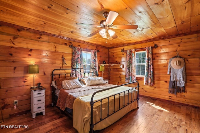 bedroom featuring wood-type flooring, wood ceiling, wooden walls, and ceiling fan