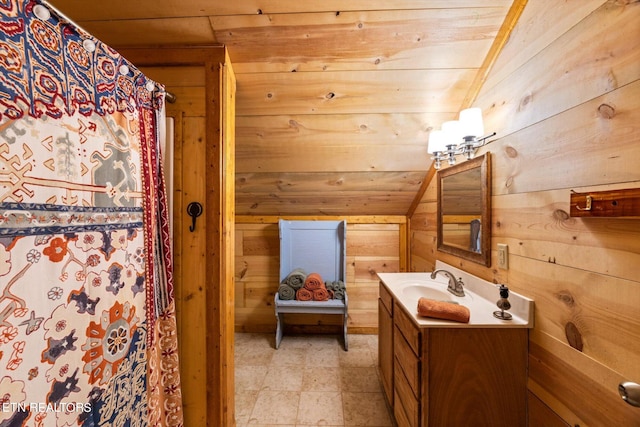 bathroom featuring wood walls, wood ceiling, vaulted ceiling, and vanity