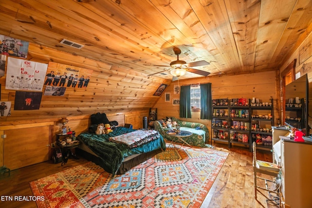 bedroom with wood ceiling, wooden walls, light hardwood / wood-style floors, and vaulted ceiling