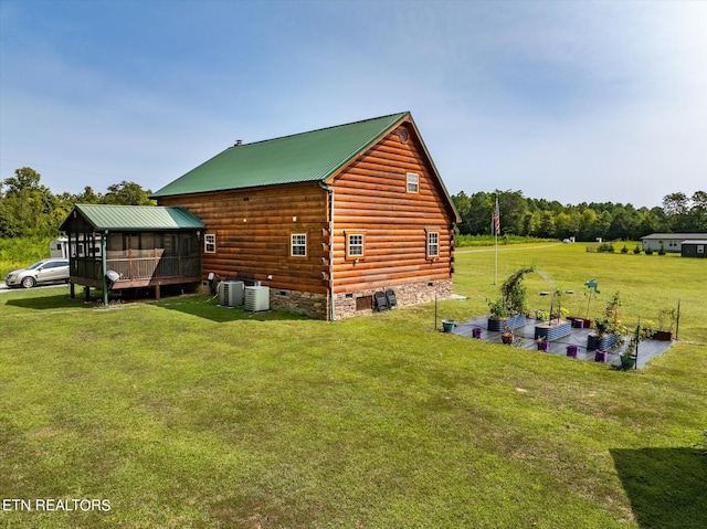 view of home's exterior with a lawn and central AC unit