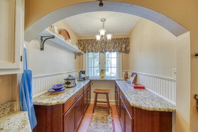 kitchen with hanging light fixtures, an inviting chandelier, light tile patterned flooring, and a textured ceiling