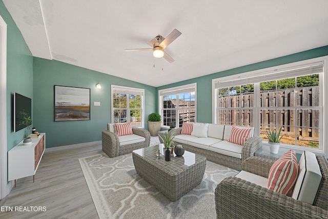 living room with ceiling fan, lofted ceiling, and light hardwood / wood-style floors