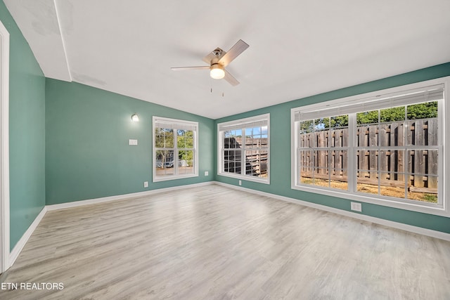 spare room with ceiling fan, vaulted ceiling, and hardwood / wood-style floors