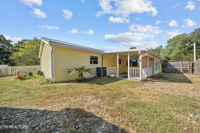 rear view of house featuring a yard and central air condition unit