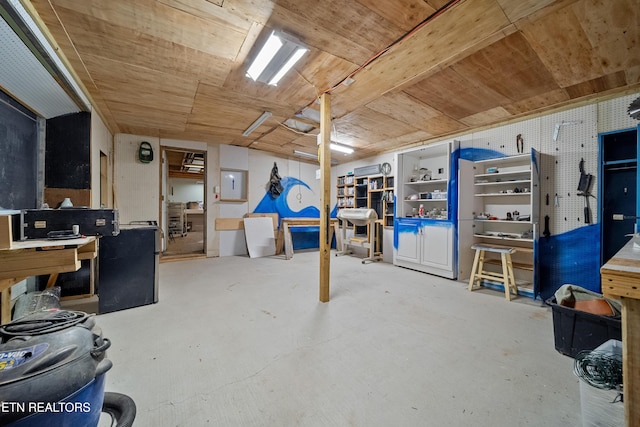 basement featuring electric panel, a workshop area, and wooden ceiling