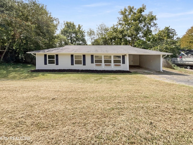 ranch-style home featuring driveway, a carport, and a front yard