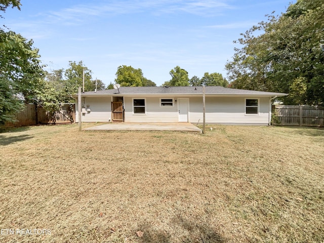 back of property featuring a yard, a patio, and fence