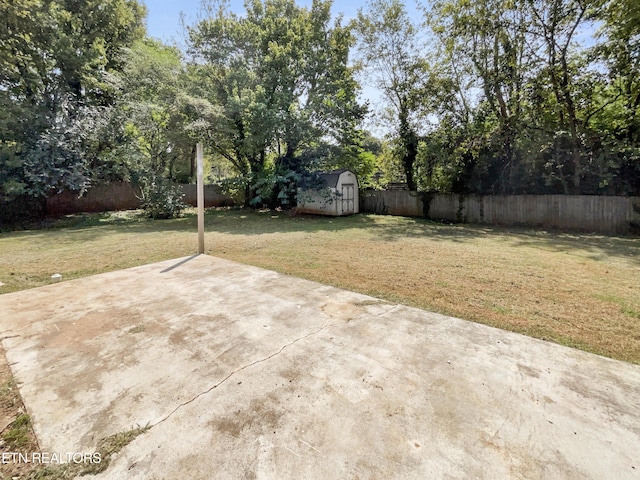 view of yard featuring a storage unit, a patio, an outbuilding, and a fenced backyard