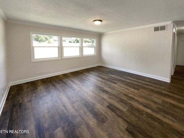 empty room featuring dark wood finished floors, visible vents, a textured ceiling, and ornamental molding