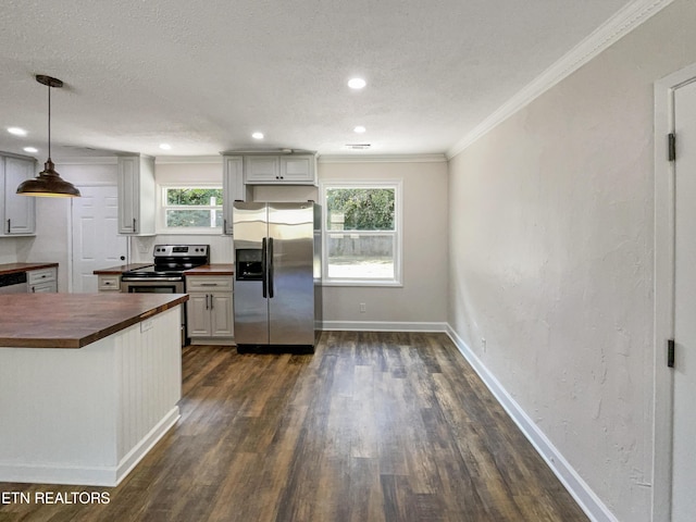 kitchen featuring butcher block countertops, stainless steel appliances, crown molding, baseboards, and dark wood-style flooring