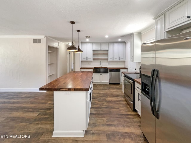 kitchen featuring open shelves, visible vents, wooden counters, and appliances with stainless steel finishes