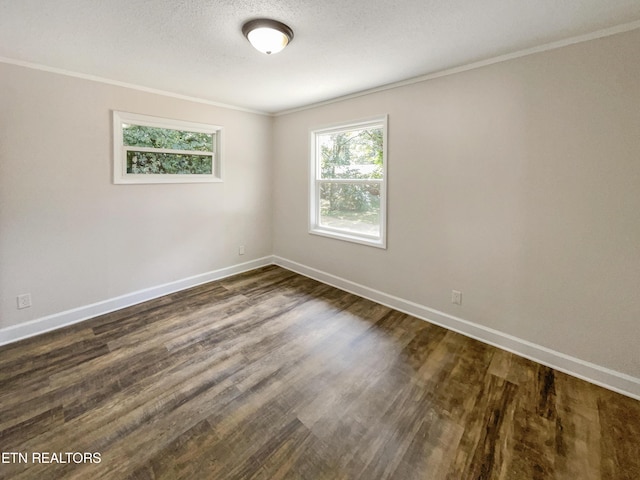 unfurnished room with dark wood finished floors, crown molding, and baseboards