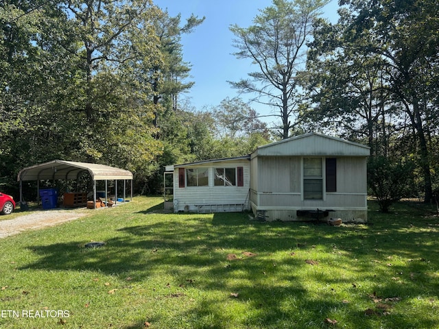 manufactured / mobile home with a front lawn and a carport