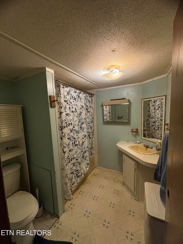 bathroom featuring a textured ceiling, curtained shower, vanity, and toilet