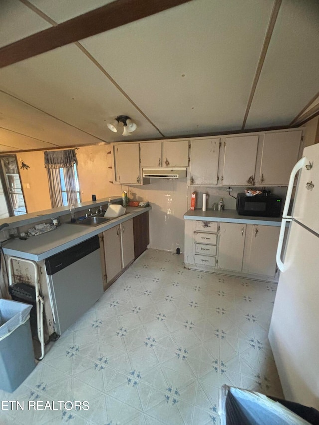 kitchen with stainless steel dishwasher, sink, and white refrigerator