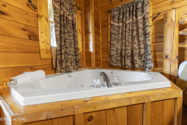 bathroom with a tub and wooden walls