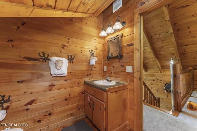 bathroom featuring vanity, wood walls, and wood ceiling