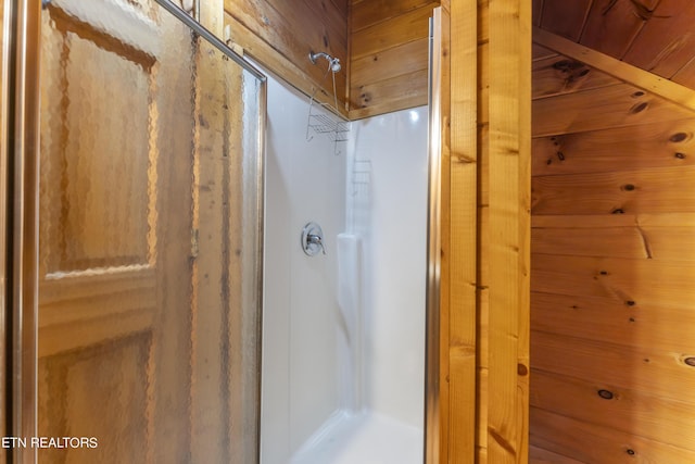 bathroom featuring walk in shower and wooden walls