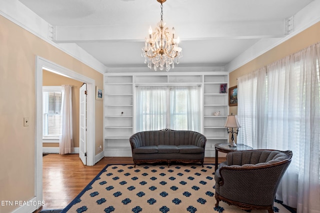 sitting room with beamed ceiling, an inviting chandelier, and light hardwood / wood-style flooring