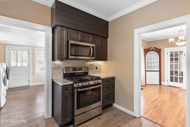 kitchen featuring dark brown cabinets, stainless steel appliances, light wood-type flooring, and washer and dryer