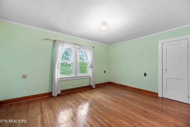 unfurnished room featuring wood-type flooring and crown molding