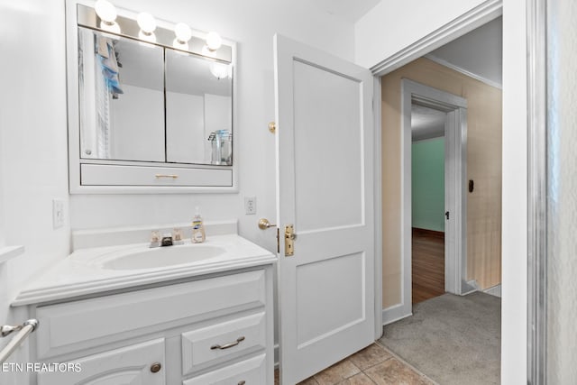 bathroom with vanity, crown molding, and tile patterned flooring