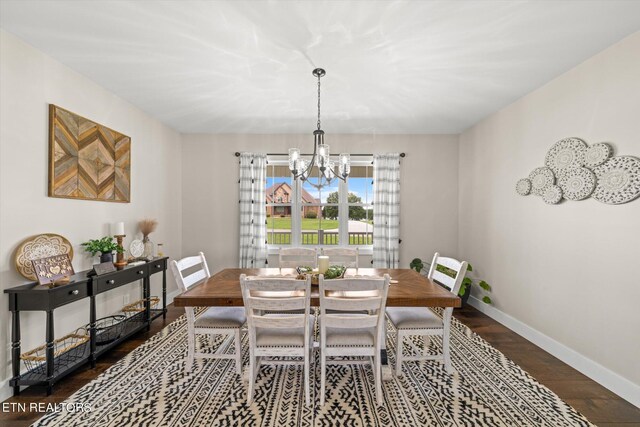 dining area with dark wood-type flooring and a chandelier