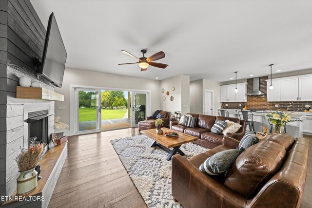 living room with ceiling fan and light wood-type flooring