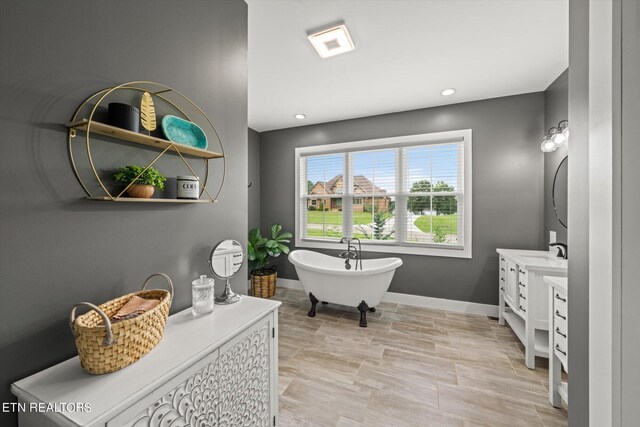 bathroom featuring a tub to relax in and vanity