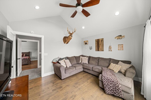 living room featuring lofted ceiling, hardwood / wood-style floors, and ceiling fan