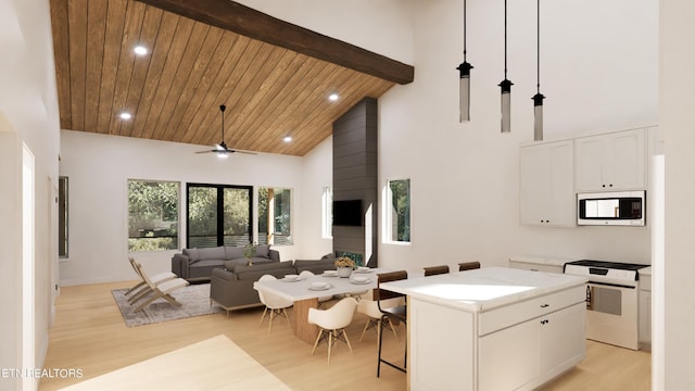 kitchen featuring a kitchen island, light hardwood / wood-style floors, white cabinets, ceiling fan, and stainless steel microwave