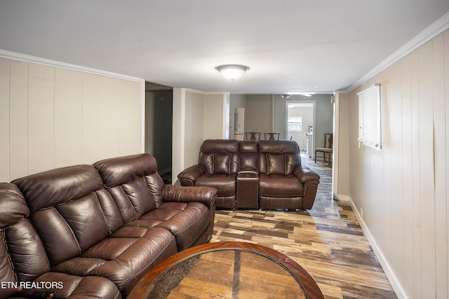 living room with light wood-type flooring, crown molding, and wooden walls