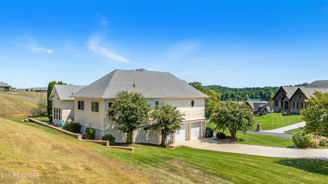 view of side of property with a yard and a garage