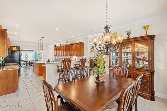 dining room featuring crown molding, a chandelier, and light tile patterned flooring