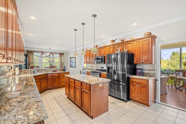 kitchen with a center island, light stone countertops, stainless steel appliances, pendant lighting, and tasteful backsplash