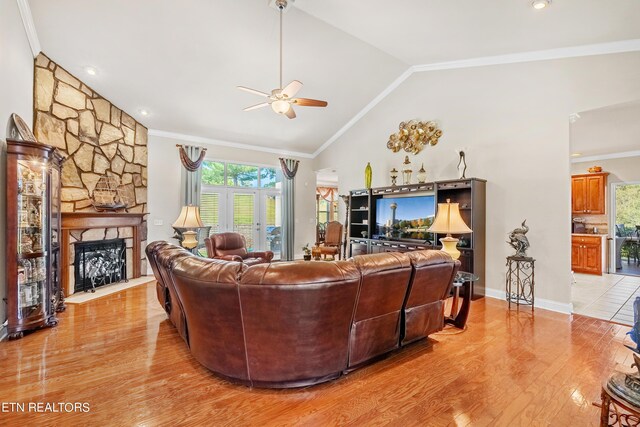 living room featuring ceiling fan, a fireplace, light hardwood / wood-style floors, and crown molding