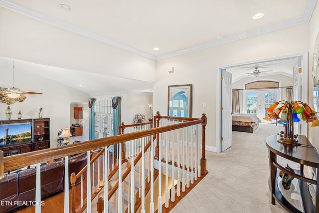 corridor featuring crown molding, vaulted ceiling, french doors, and light colored carpet