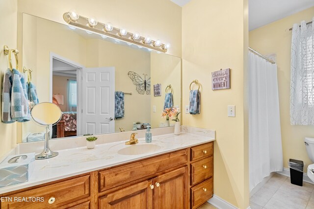 bathroom featuring vanity, toilet, and tile patterned flooring