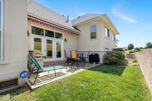 rear view of property featuring french doors, a yard, and a patio area