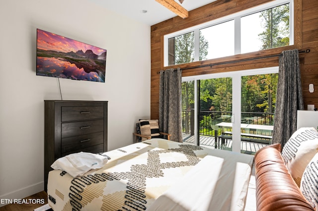 bedroom with access to exterior, hardwood / wood-style floors, wooden walls, and beam ceiling