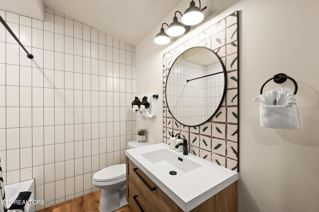 full bathroom featuring toilet, vanity, shower / bathtub combination, tile walls, and hardwood / wood-style flooring