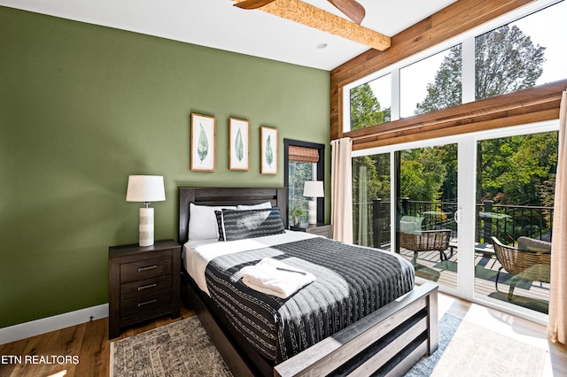 bedroom featuring beamed ceiling, hardwood / wood-style floors, and access to exterior