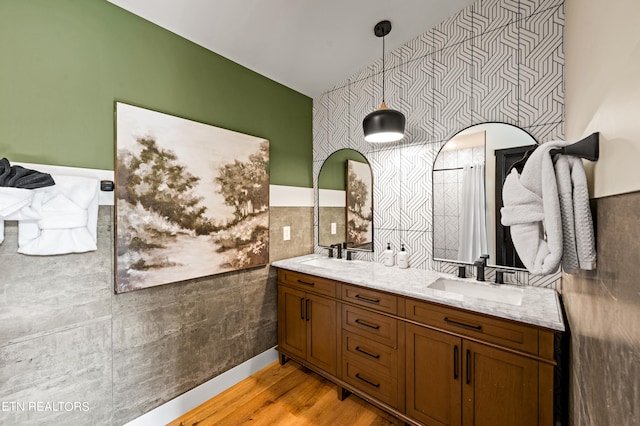 bathroom with tile walls, wood-type flooring, and vanity