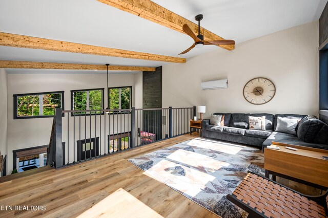 living room with hardwood / wood-style floors, ceiling fan, an AC wall unit, and vaulted ceiling with beams